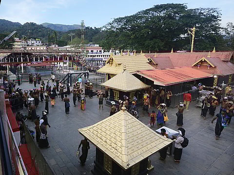 File photo: Devotees carrying customary offerings on their heads, arrive to worship at the Sabarimala temple. 