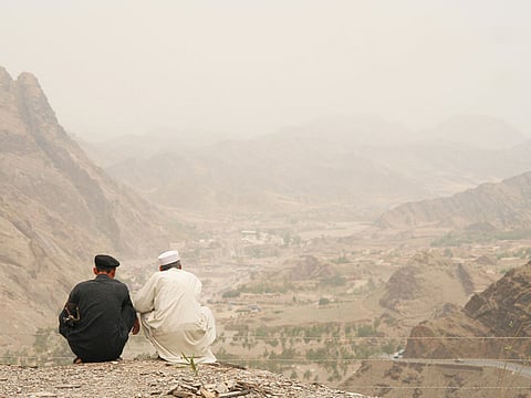 Two men look over the mountains near the Khyber Pass.