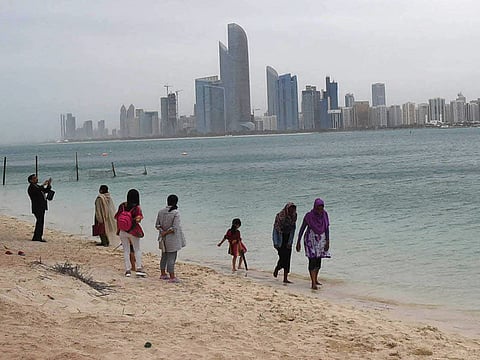Abu Dhabi residents walk at the beach