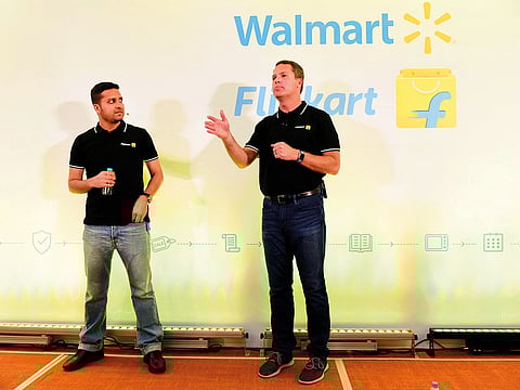 In this file photo taken on May 9, 2018, Binny Bansal (L), co-founder of Flipkart, looks on as Walmart CEO Doug McMillon (R) speaks at an event to announce Walmart was buying a stake in Flipkart, in Bangalore. 