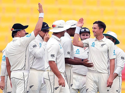 New Zealand’s Trent Boult celebrates with teammates after claiming a wicket.