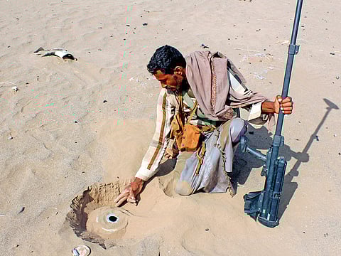 A member of the Yemeni pro-government forces looks for mines on the eastern outskirts of Hodeida.