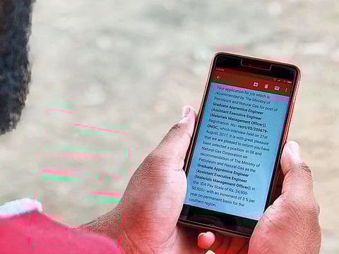 Sampat displays an email offering him a job with a state-owned Indian oil and gas company. The offer was fake.