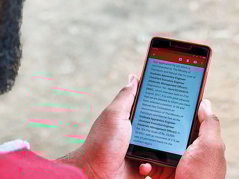 Sampat displays an email offering him a job with a state-owned Indian oil and gas company. The offer was fake.