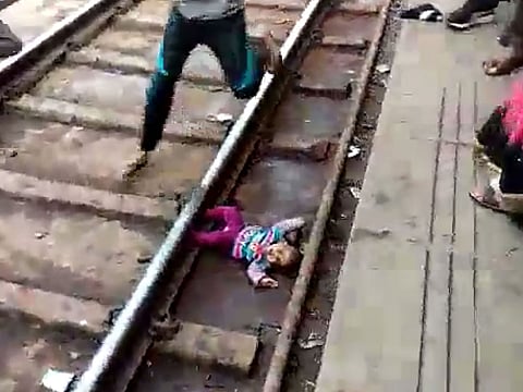 This screengrab taken from a video shot on November 20, 2018 and provided by NNIS shows a baby girl next to train tracks at the train station in Mathura in India's Uttar Pradesh state.