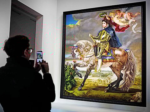 A man takes a picture of a painting by Kehinde Wiley depicting Michael Jackson titled "Equestrian Portrait of King Philip II (Michael Jackson)" at the "Off the Wall" exhibition on the influence of Michael Jackson by some of leading names in contemporary art at the Grand Palais in Paris.