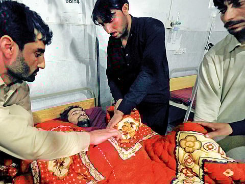 Relatives attend to a man in a Peshawar hospital after he was injured in the blast in Orakzai.