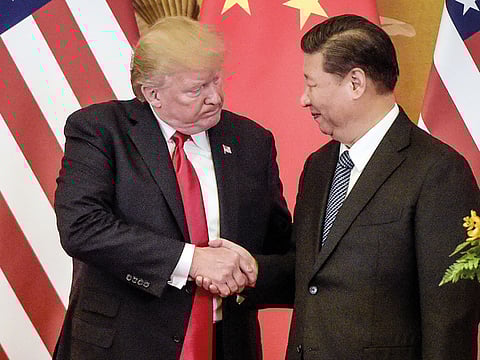 File photo: US President Donald Trump and China’s President Xi Jinping shake hands in Beijing last year. 