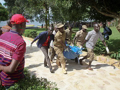Ugandan police carry away a body of one of the victims of a boat which capsized in Lake Victoria near the capital, Kampala, Uganda, Sunday, Nov. 25, 2018. Police say dozens died when the boat, which was carrying more than 90 passengers on a pleasure cruise, capsized Saturday evening. 