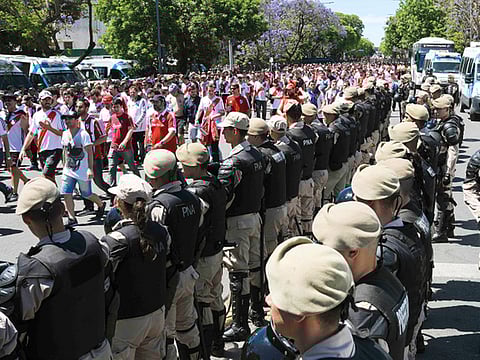 Security forces stand guard as River Plate’s supporters leave the Monumental stadium in Buenos Aires.