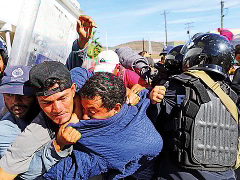 Migrants clash with Mexican police at the Mexico-U.S. border after getting past another line of Mexican police at the Chaparral crossing in Tijuana, Mexico, Sunday, Nov. 25, 2018, as they try to reach the US.