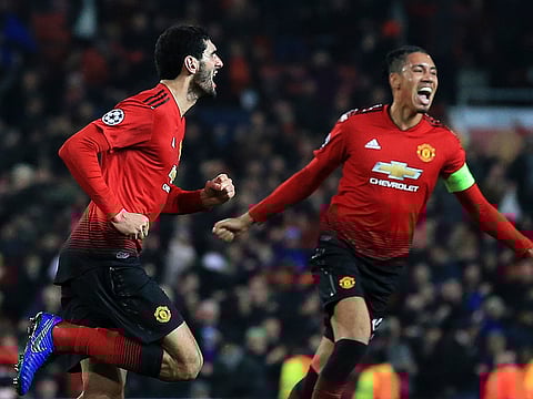 Manchester United midfielder Marouane Fellaini, left, celebrates after scoring.