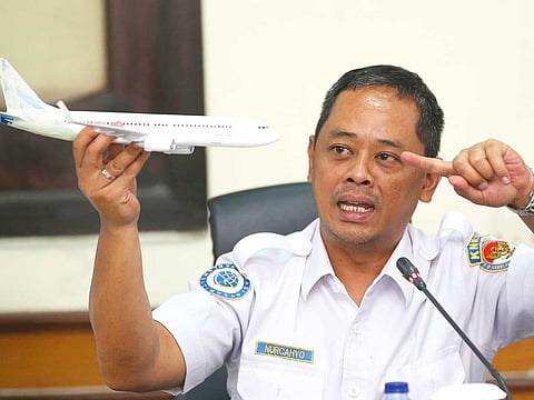 National Transportation Safety Committee investigator Nurcahyo Utomo holds a model of an airplane during a press conference on the committee's preliminary findings on their investigation on the crash of Lion Air flight 610