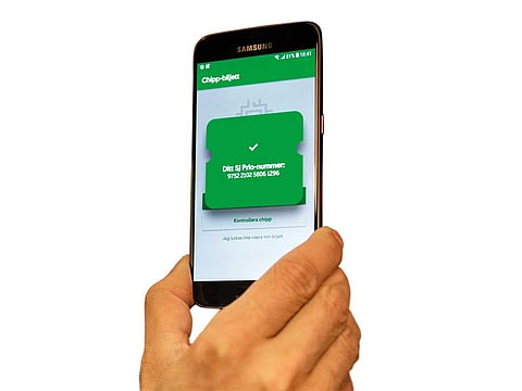 An app interacts with a microchip implanted in a person’s hand, which allows them to pay for services with a wave, in Stockholm, Sweden. 