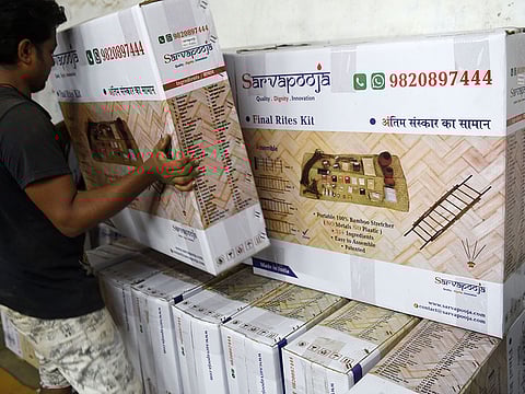 A worker arranges boxes of the SarvaPooja "final rites kit" at their manufacturing unit in Mumbai. 