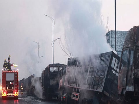 Firefighters try to extinguish burning vehicles in the aftermath of an explosion at a plant operated by the Hebei Shenghua Chemical Industry Co. Ltd that destroyed dozens of vehicles nearby on Wednesday, Nov. 28, 2018 in Zhangjiakou city