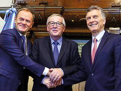 Argentina's President Mauricio Macri (R) welcoming the President of the European Commission Jean-Claude Juncker (C) and President of the European Council Donald Tusk, on arrival in Buenos Aires on November 29, 2018. 