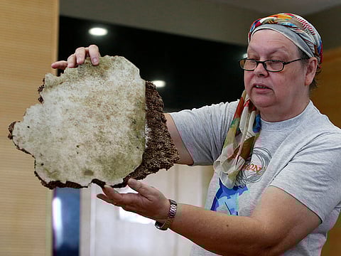 Jacquita Gonzales, the wife of in-flight supervisor Patrick Francis Gomes, who was onboard the missing Malaysia Airlines MH370, displays debris believed to belong to MH370 before handing over to Malaysia's Transport Minister Anthony Loke Siew Fook in Putrajaya, Malaysia November 30, 2018.