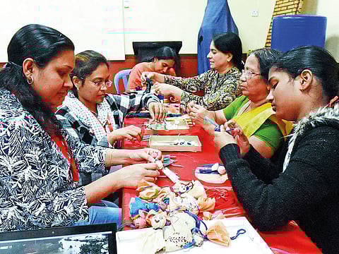 Friends of KSSP members making the ‘Chekkutty’ dolls using traditional handloom saris damaged in the Kerala floods.
