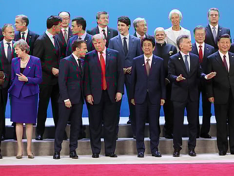 US President Donald Trump, front center, listens to France's President Emmanuel Macron as they pose with world leaders for a group picture at the start of the G20 Leader's Summit inside the Costa Salguero Center in Buenos Aires, Argentina.  