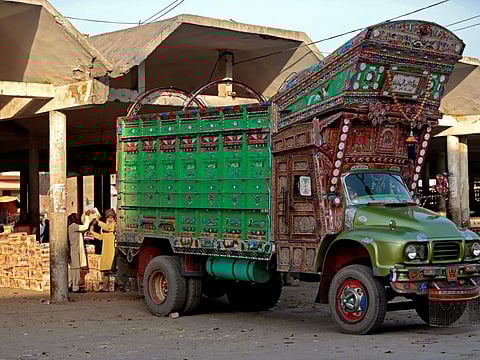 Fruit is unloaded from a truck at a produce market in Faisalabad, Pakistan.