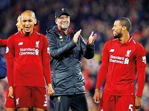 Liverpool manager Juergen Klopp applauds the fans as Georginio Wijnaldum and Fabinho celebrate at the end of the match against Everton at Anfield on Sunday.