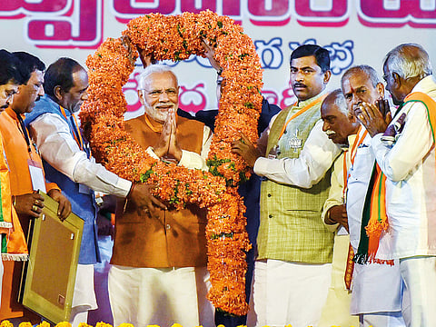 Prime Minister Narendra Modi is garlanded by party leaders in Telangana during a BJP election campaign ahead of the state Assembly elections at LB Stadium, in Hyderabad, on Monday.