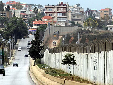 This picture taken on December 4, 2018 from the southern Lebanese village of Kfar Kila shows a view of the border with Israel, with Israeli vehicles driving on the right side and UN and Lebanese vehicles driving on the left. 