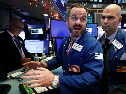 Specialist Charles Boeddinghaus, centre, works at his post on the floor of the New York Stock Exchange at the close of trading, Monday, Dec. 3, 2018. 