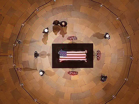 US President Donald Trump and First Lady Melania pay their respects to George HW Bush in the Capitol Rotunda in Washington.