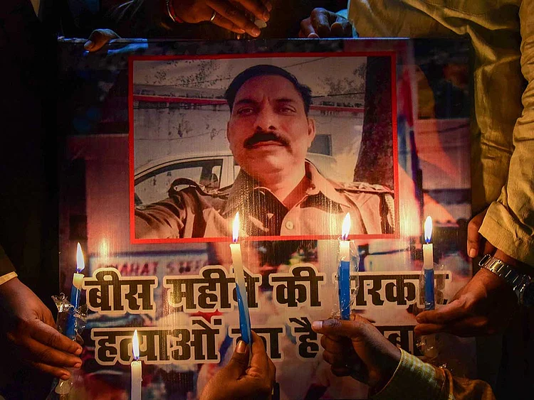 Samajwadi Party workers take part in a candle light march