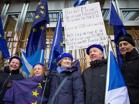 Pro-European activists protest outside the Scottish Parliament, in Edinburgh, Wednesday, Dec. 5, 2018. Britain's Brexit debate has become a bruising battle between lawmakers and Prime Minister Theresa May's government. 
