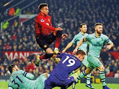Manchester United’s Jesse Lingard (top) jumps past Arsenal goalkeeper Bernd Leno (centre) after scoring their second goal to equalise 2-2 at Old Trafford.