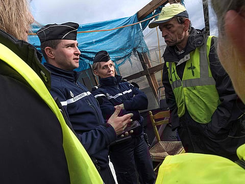 French Gendarme speak with members of the "yellow vest" or "Gilets jaunes" as they protest at the Gaulois roundabout at Saint Beauzire in central France on December 6, 2018. 