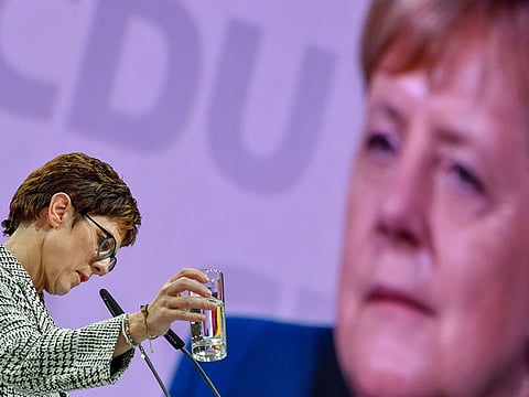 The Secretary General of the Christian Democratic Union (CDU) and candidate for the party's leadership Annegret Kramp-Karrenbauer gives a speech as Angela Merkel appears on a screen during a party congress to determine German chancellor's successor on December 7, 2018 at a fair hall in Hamburg, northern Germany.
