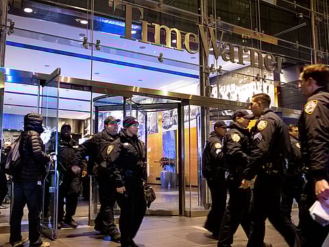 After the building was determined safe, New York City police officers walk from the Time Warner Center in New York Thursday, Dec. 6, 2018, after a bomb threat was called into the building and occupants were evacuated, including CNN employees.