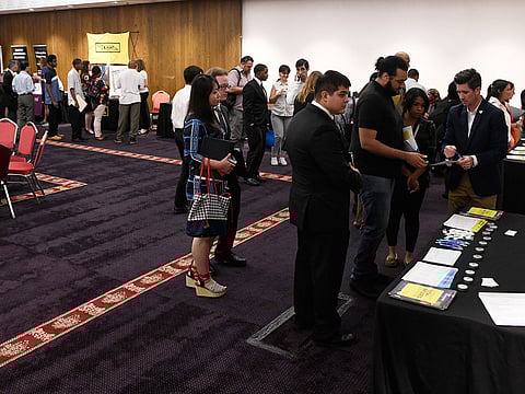 In this June 20, 2018, file photo people attend a job fair in Chicago. On Friday, Dec. 7, the U.S. government issues the November jobs report.