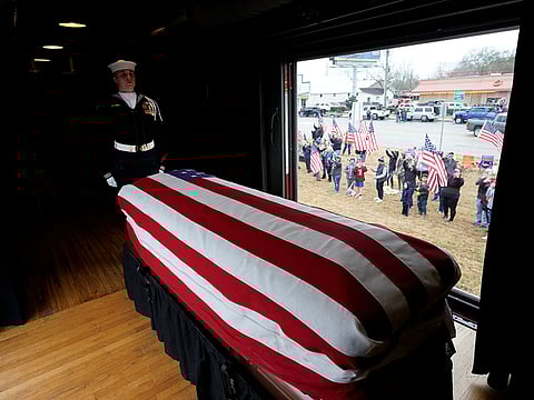 People pay their respects as the train carrying the casket of former President George H.W. Bush passes Thursday, Dec. 6, 2018, along the route from Spring to College Station, Texas. 