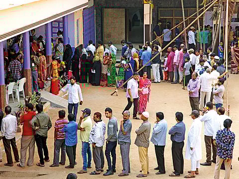 Indian people stand in a queue to cast their votes in Hyderabad, India, Friday, Dec. 7, 2018.