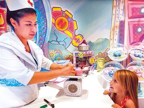 Nurse Tania, aka Danielle Hernandez, weighs and examines Susiking, one of the babies from the planet Neonatopia, at the Distroller World store in San Diego, as 4-year-old Sydney Stephens looks on. 