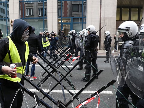 A demonstrator confronts the police at a barricade during the "yellow vests" protest against higher fuel prices, in Brussels, Belgium, December 8, 2018.