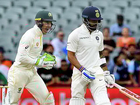 Australia's captain Tim Paine (L) celebrates as India's captain Virat Kohli leaves the field after being dismissed on day three of the first test match between Australia and India at the Adelaide Oval in Adelaide, Australia, December 8, 2018.