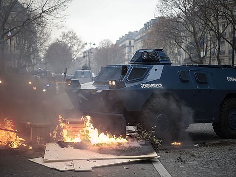 Gendarmerie armored vehicles (VBRG) drives past fire near the Champs Elysees avenue in Paris on December 8, 2018