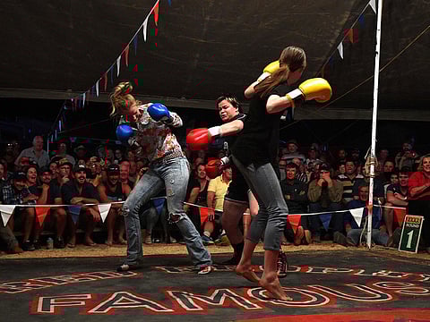 Brettlyn Neal "The Beaver" (C) fighting two women who jointly challenged her for a round in Fred Brophy's boxing troupe tent in the Queensland town of Birdsville. 