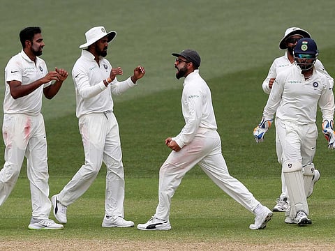 India's Virat Kohli, centre, celebrates with his teammates after defeating Australia by 31 runs to win the first cricket test in Adelaide, Australia, Monday, Dec. 10,  2018. 
