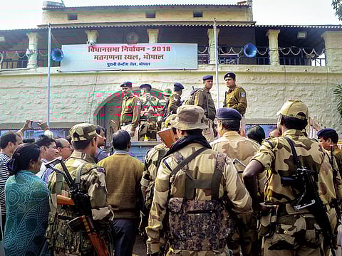 Security forces stand guard as postal ballots are carried inside central jail, ahead of counting of votes for Assembly elections in Bhopal, Madhya Pradesh.