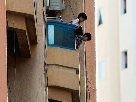 Kids leaning dangerously from balcony of an apartment in Al Nahda, Sharjah.