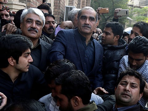 Senior politicians from ex-Prime Minister Nawaz Sharif's party Khawaja Saad Rafique, in blue coat, and his brother Khawja Salman Rafique, second left, leave a court in Lahore, Pakistan, Tuesday, Dec. 11, 2018. 