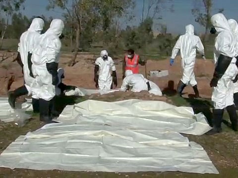 A handout picture released by the official Syrian Arab News Agency (SANA) on December 12, 2018 shows what Syrian authorities say are forensic experts digging out a mass grave in the area of Boukamal in the countryside of the Syrian province of Deir Ezzor on December 11, 2018.