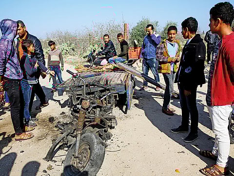 In this Monday, Nov. 12, 2018 file photo, Palestinians inspect a vehicle that was destroyed in an Israeli raid that killed seven Hamas Palestinian militants, including a local Hamas commander, east of Khan Younis, southern Gaza Strip.